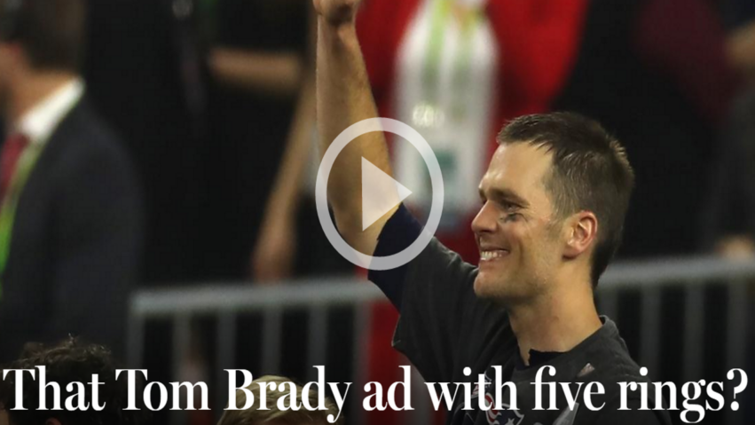 Football player celebrating with raised fist during a sports event, surrounded by a cheering crowd in the background.