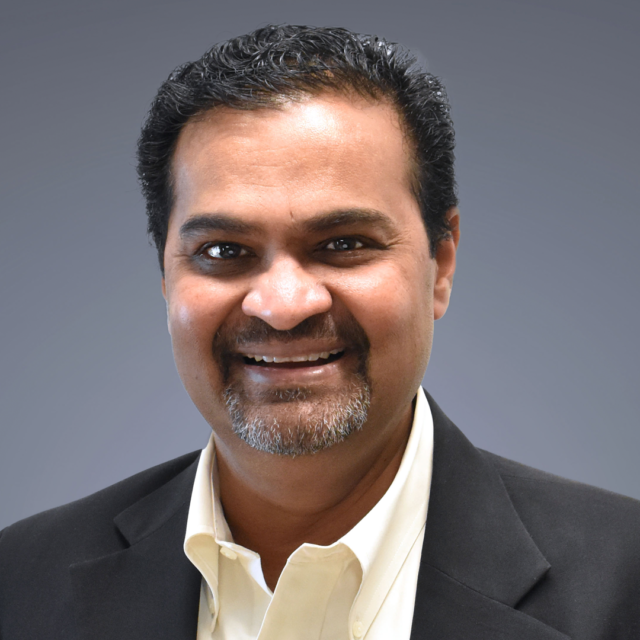 Smiling man in a suit with a light blue background