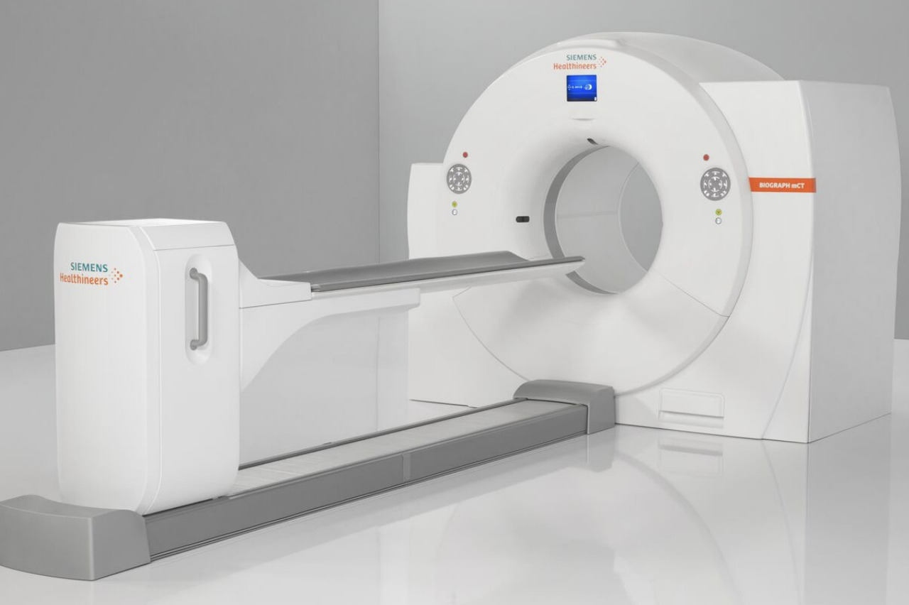 Modern CT scanner in a hospital setting with a sleek design, featuring a large circular opening and a patient table.