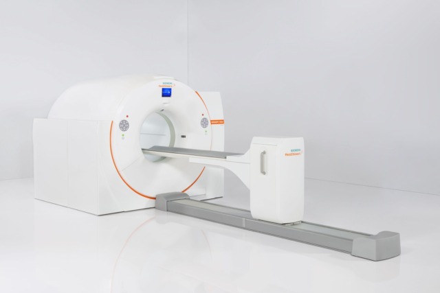 MRI machine in a white room with an extended table used for medical imaging and diagnostic purposes