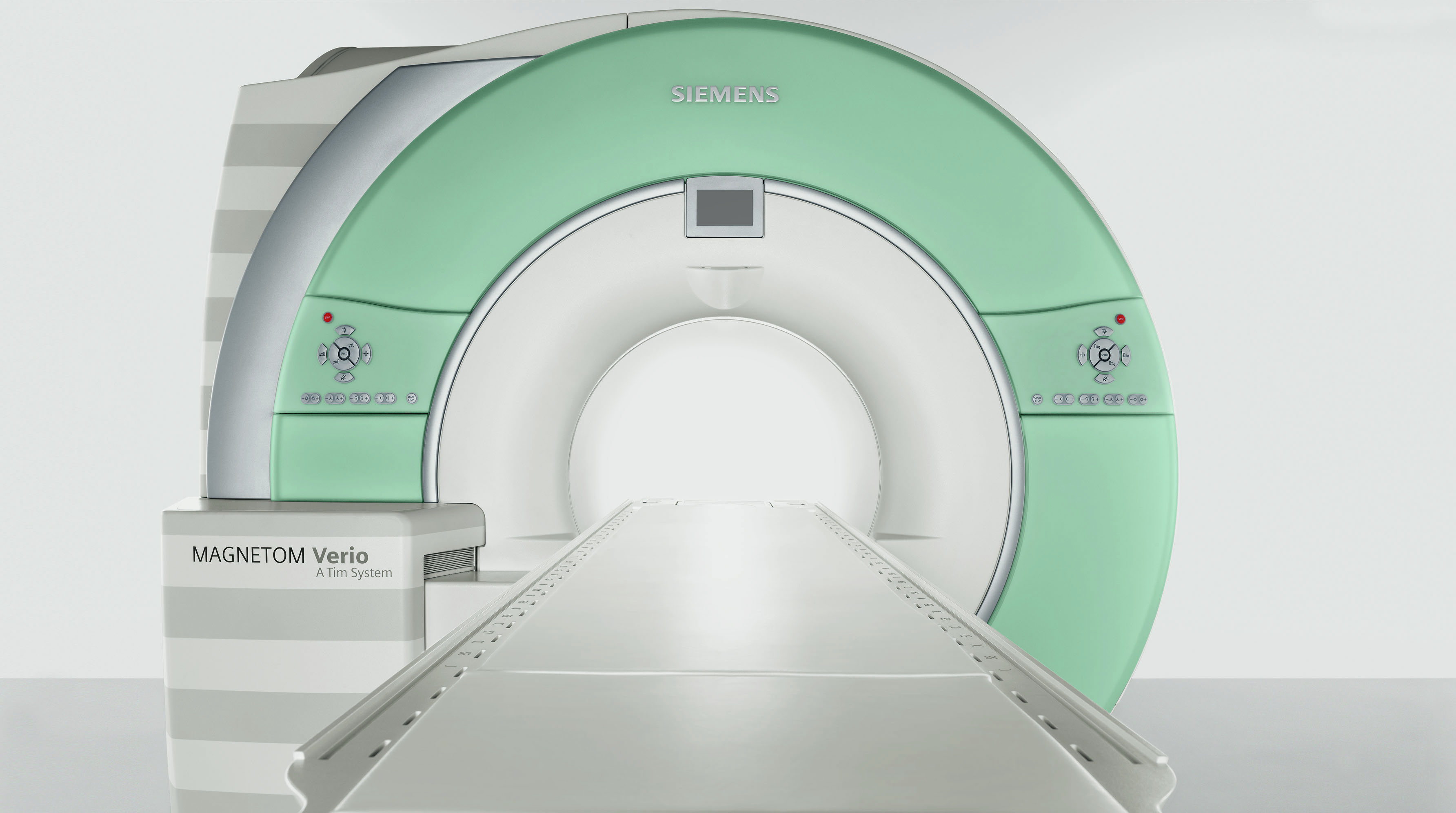 MRI machine in a hospital setting with a green and white design, featuring a long examination table leading into the scanner.