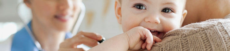 Smiling baby receiving a vaccination shot in the arm.
