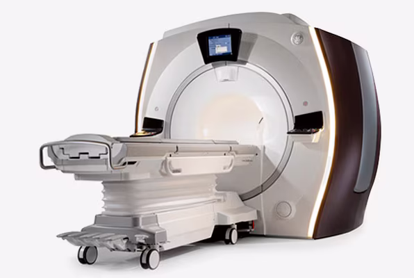 MRI machine in a hospital setting with a patient bed ready for scanning.